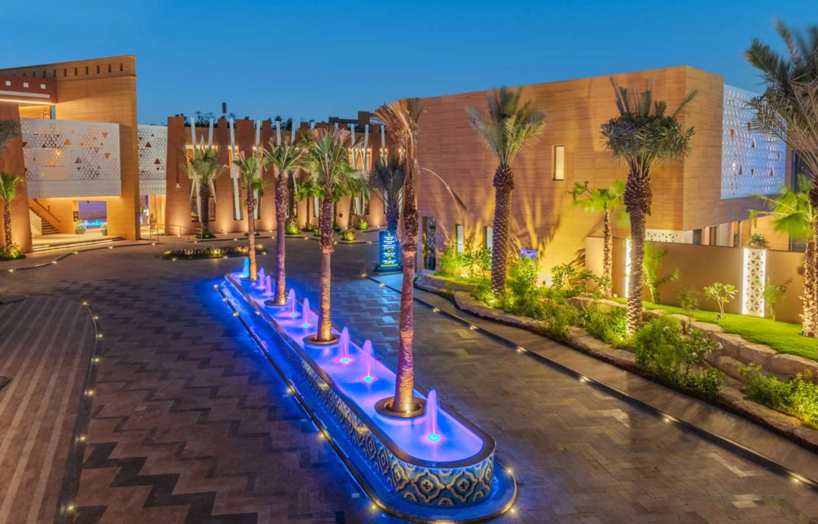 Illuminated courtyard with palm trees at Vivienda Riyadh Diplomatic Quarter, Riyadh, KSA