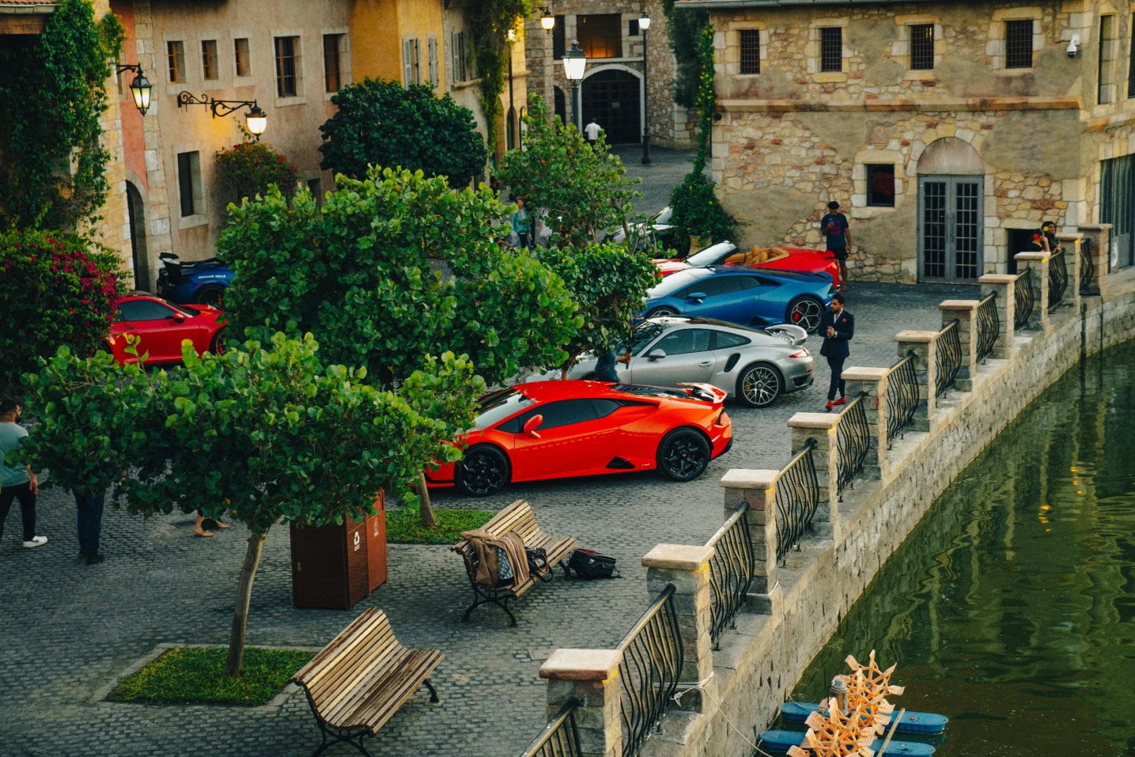 Luxury cars parked along cobblestone street at Dubai Parks and Resorts, Dubai, UAE.