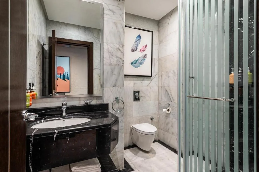 Elegant bathroom with marble walls at Holiday Inn Riyadh al Malaz by IHG.