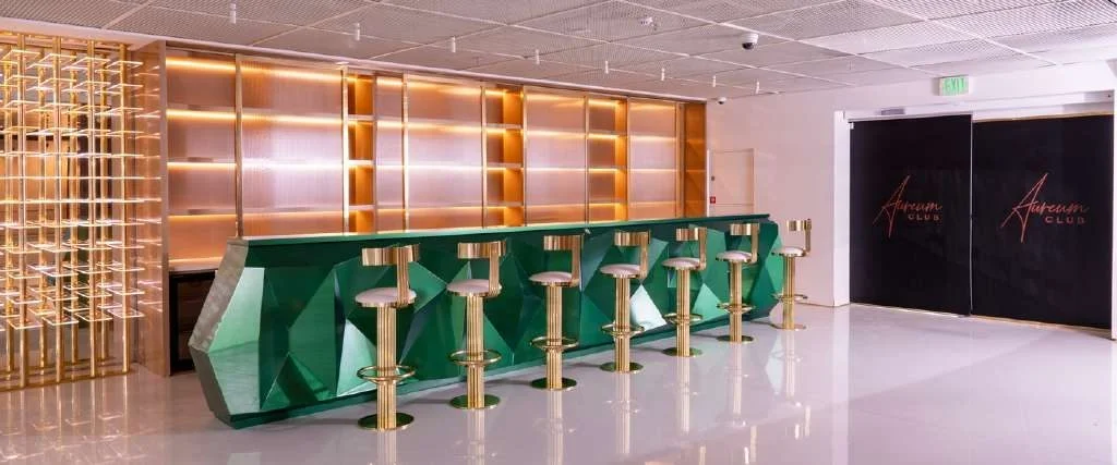Modern bar area with green counter at Aureum Club, Dubai, UAE