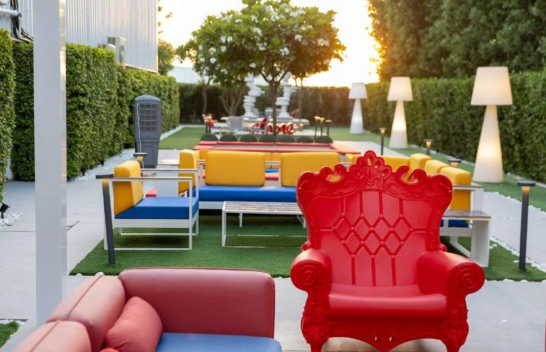 Colorful outdoor seating area with lamps at Aureum Club, Dubai, UAE.