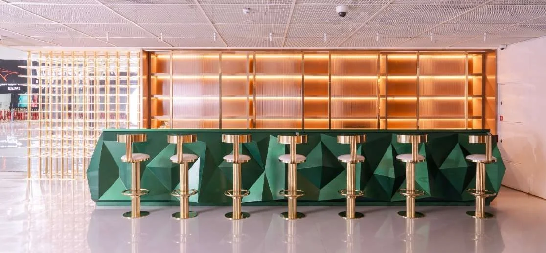 Modern bar area with green geometric counter at Aureum Club, Dubai, UAE