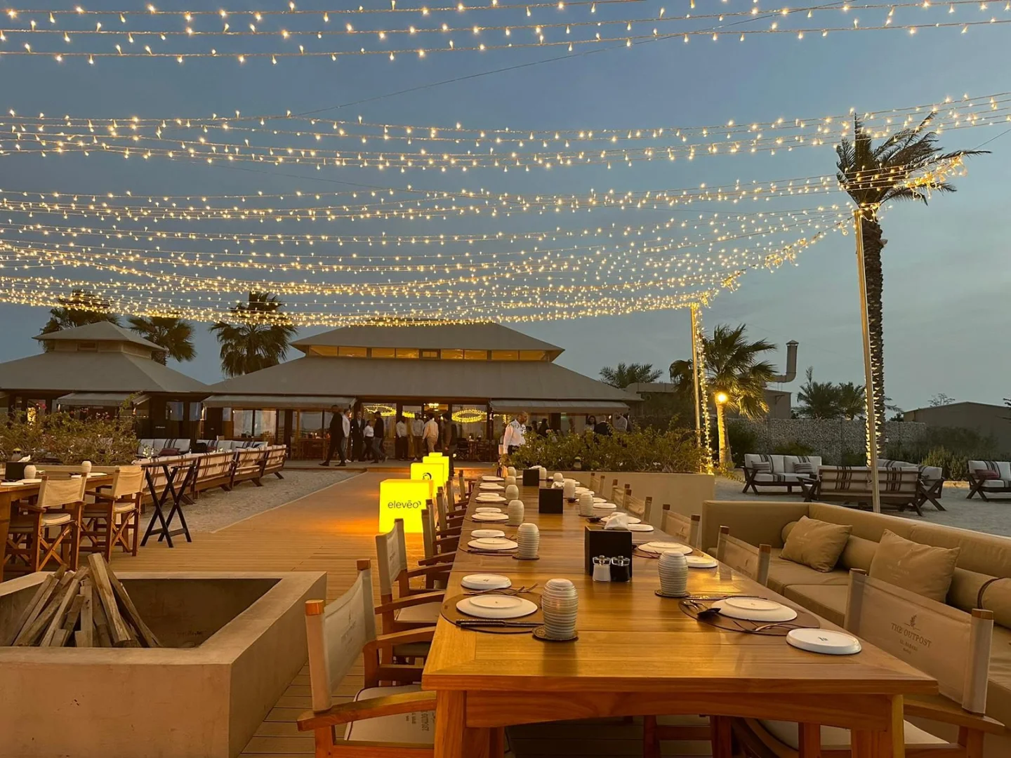 Outdoor dining setup with string lights at The Outpost Al Barari, Doha, QATAR