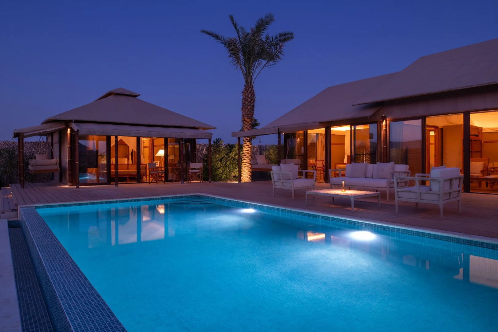 Poolside seating area at The Outpost Al Barari, Doha, Qatar
