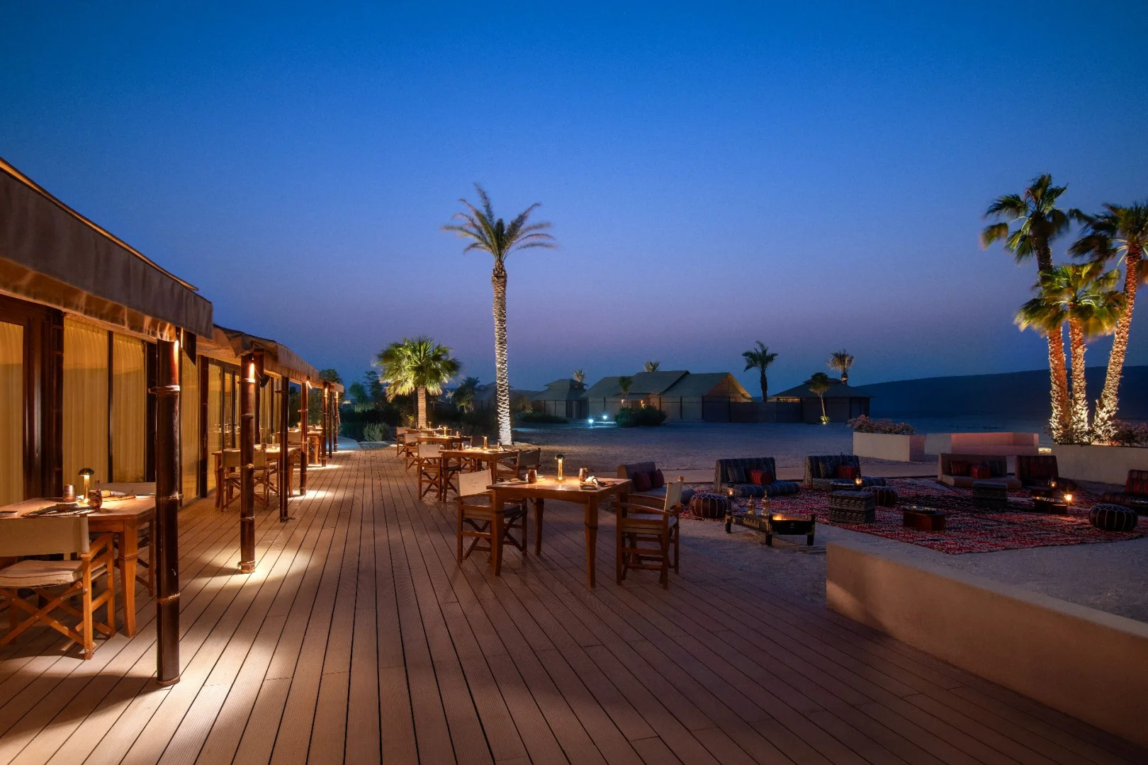 Outdoor seating and palm trees at The Outpost Al Barari, Doha, Qatar